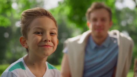 niño comiendo sonriendo a la cámara en un picnic en primer plano. retrato de un niño gracioso en la naturaleza