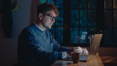 Man Working on Laptop in Dark Room during Night