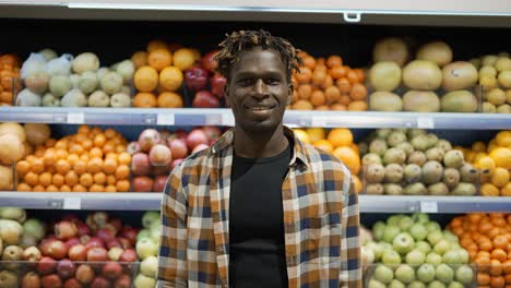 Portrait-Of-Handsome-Young-Man-Looking-At-Camera-And-Smiling-In-Supermarket