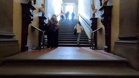 visitors ascending stairs in uffizi gallery, florence