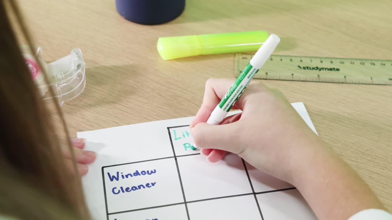 Person writing on a table with markers