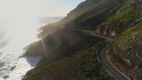 drone view panning across a mountain pass road next to the sea