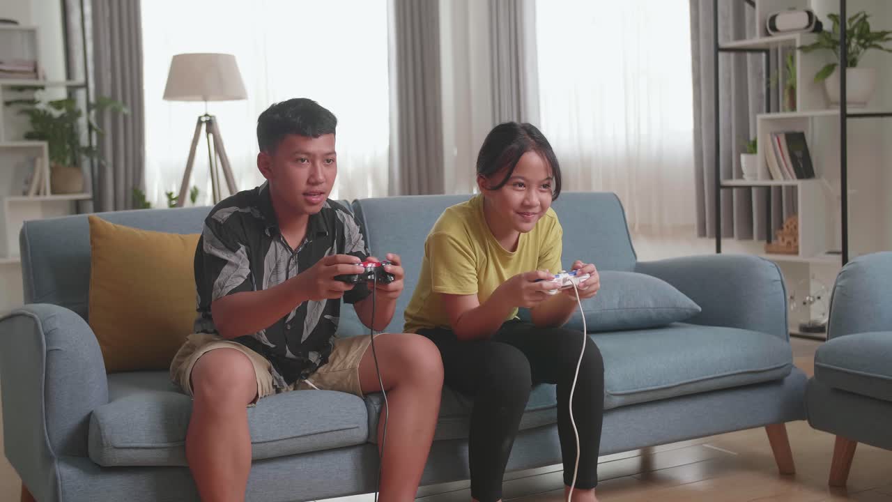 Asian Children With Joystick Game Play Video Game On Tv And Celebrating Victory
