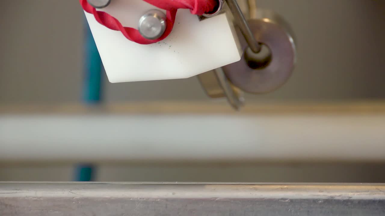 Lids being placed onto cans of beer on a production line as some of the contents overflow CLOSE UP