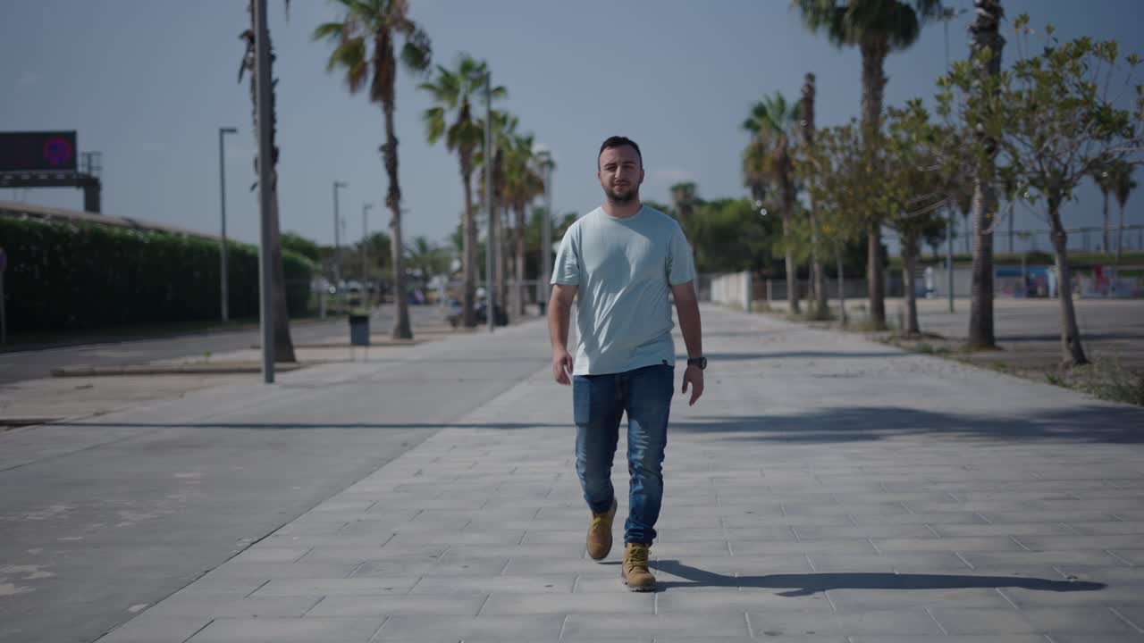 Man Walking on a City Street by Palm Trees