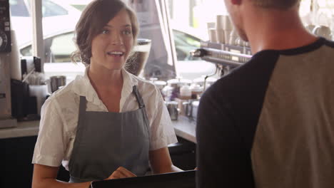 man paying cafe bill using digital tablet shot on r3d