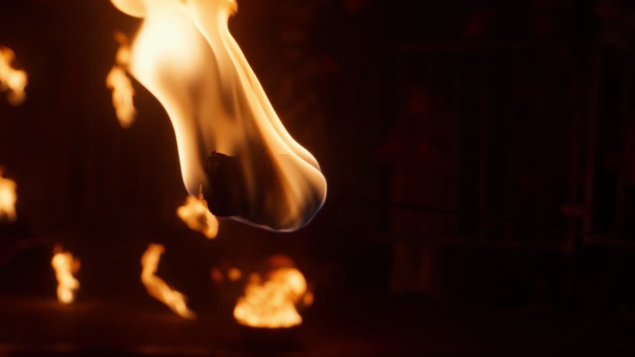 Slow-motion night fire performance at festival with mystical atmosphere