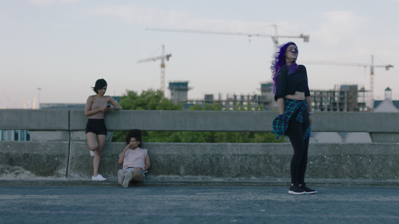 춤을 추는 여자 아름다운 혼합 인종 댄서 도시 스타일 거리 춤을 공연 도시에서 프리스타일 움직임을 연습하는 친구들이 시청하고 해가 지는 것을 즐기고