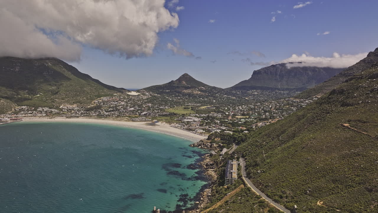 Cape Town South Africa Aerial v87 flyover Chapman's peak drive capturing views of Hout Bay, a scenic coastal suburb with sandy beach, and turquoise waters - Shot with Mavic 3 Pro Cine - Jan 11th 2024