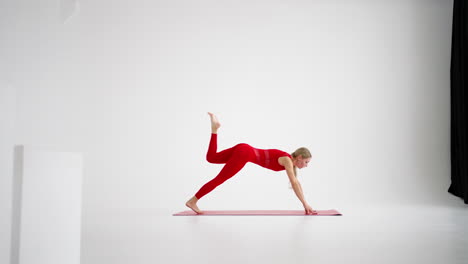 mujer joven muestra ejercicios de yoga o pilates. mujer joven atractiva practicando yoga en el estudio. chica muestra diferentes posturas para el yoga en fondo blanco. estilo de vida saludable yoga en mi corazón deportes