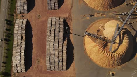 montones de troncos y montañas de aserrín en la fábrica de papel