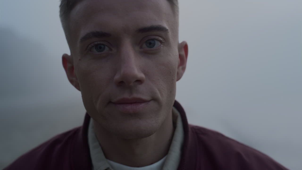 Thoughtful guy looking away outdoors. Portrait of serious man posing at camera