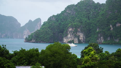 Yate-Navegando-En-El-Océano-Rodeado-De-Acantilados-De-Piedra-Caliza-En-La-Isla-De-Koh-Phi-Phi,-Tailandia