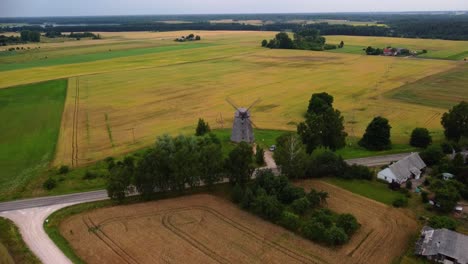 Toma-Aérea-De-Un-Antiguo-Molino-De-Viento-En-El-Campo,-Acercándose