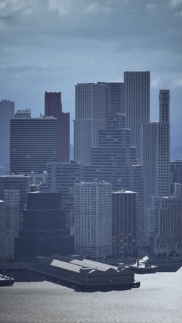 a panoramic view of a city skyline with tall buildings and a river in the foreground