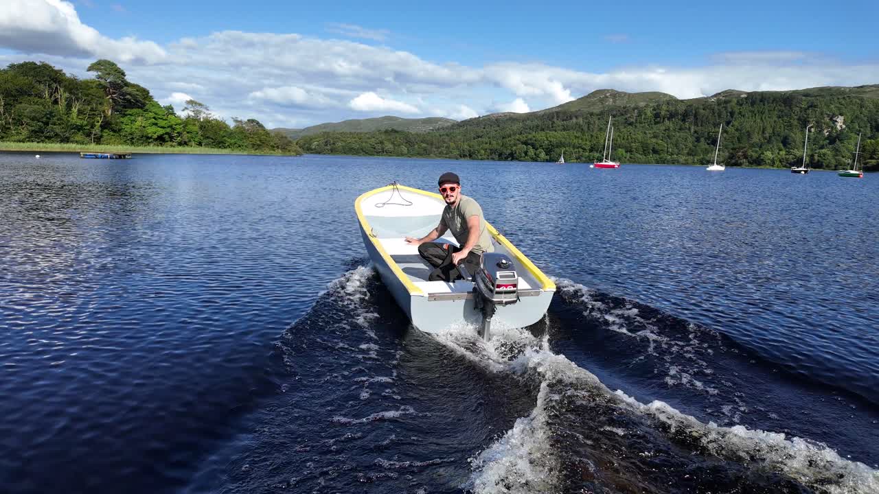 Man Cruising a Small Motorboat on a Picturesque Lake