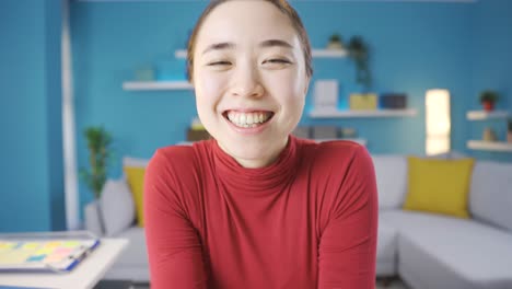 젊은 아시아 여성이 에너지로 가득 찬 카메라를 쳐다보고 있습니다.