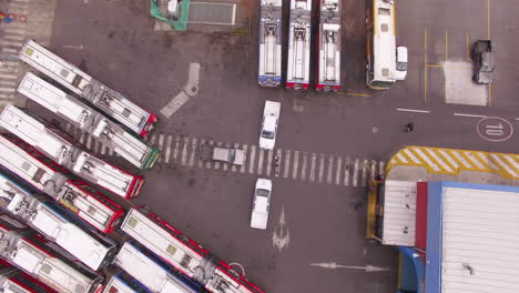 overhead of three cars parked in the center of a bus station