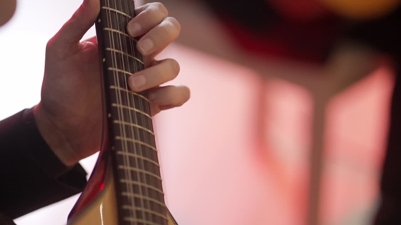 Close up of a musician playing a Portuguese guitar during a fado performance