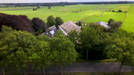 aerial of beautiful farmhouse in meadows in rural netherlands