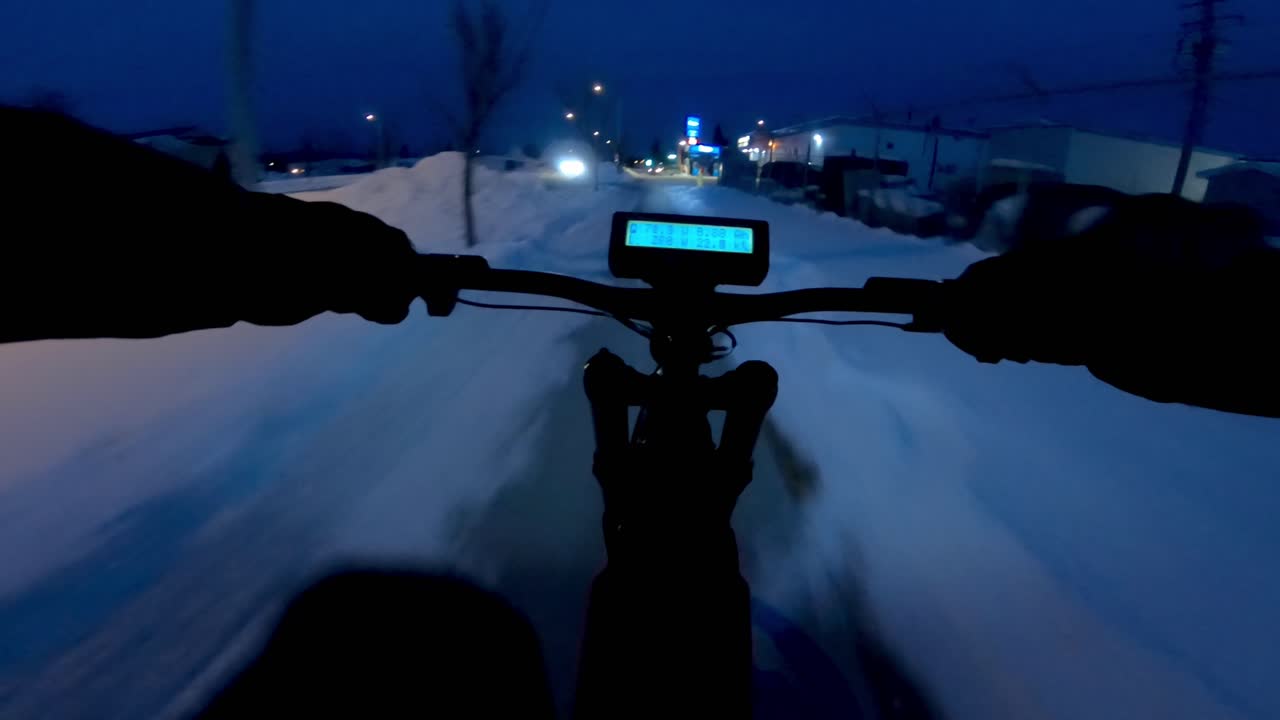 Man going for a ride on his ebike during winter time at night