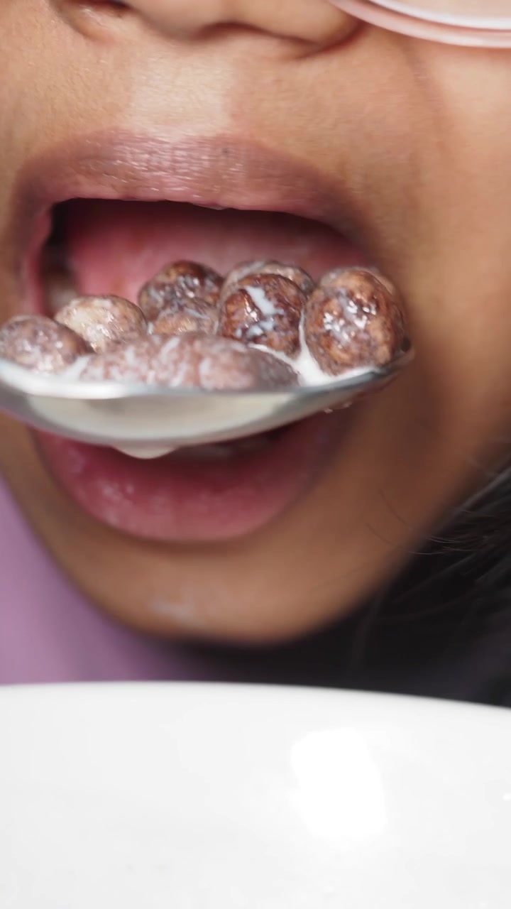 Close-up of a Child Eating Chocolate Cereal with Milk