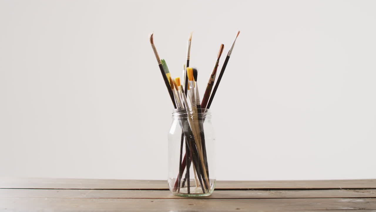 복사 공간과 함께 색 배경에 항아리에 서 있는 페인트 브러쉬의 컬렉션의 비디오