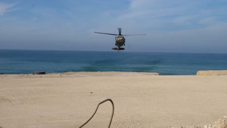 an iaf uh-60 blackhawk hovering over mediterranean sea before landing in gaza