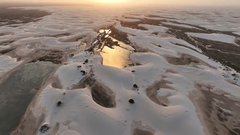 golden sunset at lencois maranhenses white sand dunes, aerial dolly in