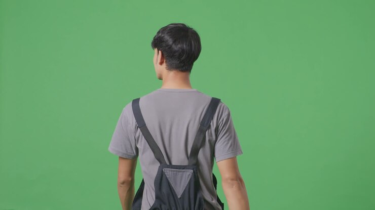 Man in overalls, back view, against green screen