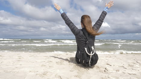 mujer sentada en la arena admira el mar y el horizonte