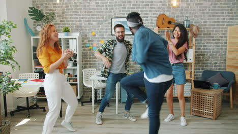 friends dancing in a modern office