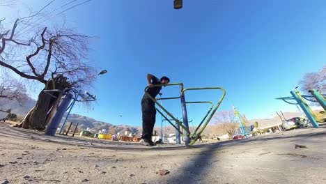 young south american male trains calisthenics in outdoors public park, panoramic view, mountain background and traffic
