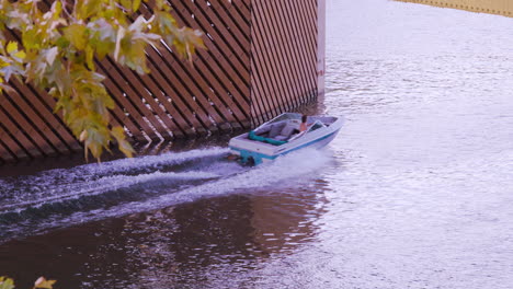 Ein-Boot-Rast-Unter-Der-Tower-Bridge-In-Sacramento,-Kalifornien-Hindurch-Und-Hinterlässt-Eine-Kaskadierende-Spur-Aus-Wellen,-Die-Sich-Durch-Das-Wasser-Kräuseln,-Wenn-Sie-Langsamer-Werden