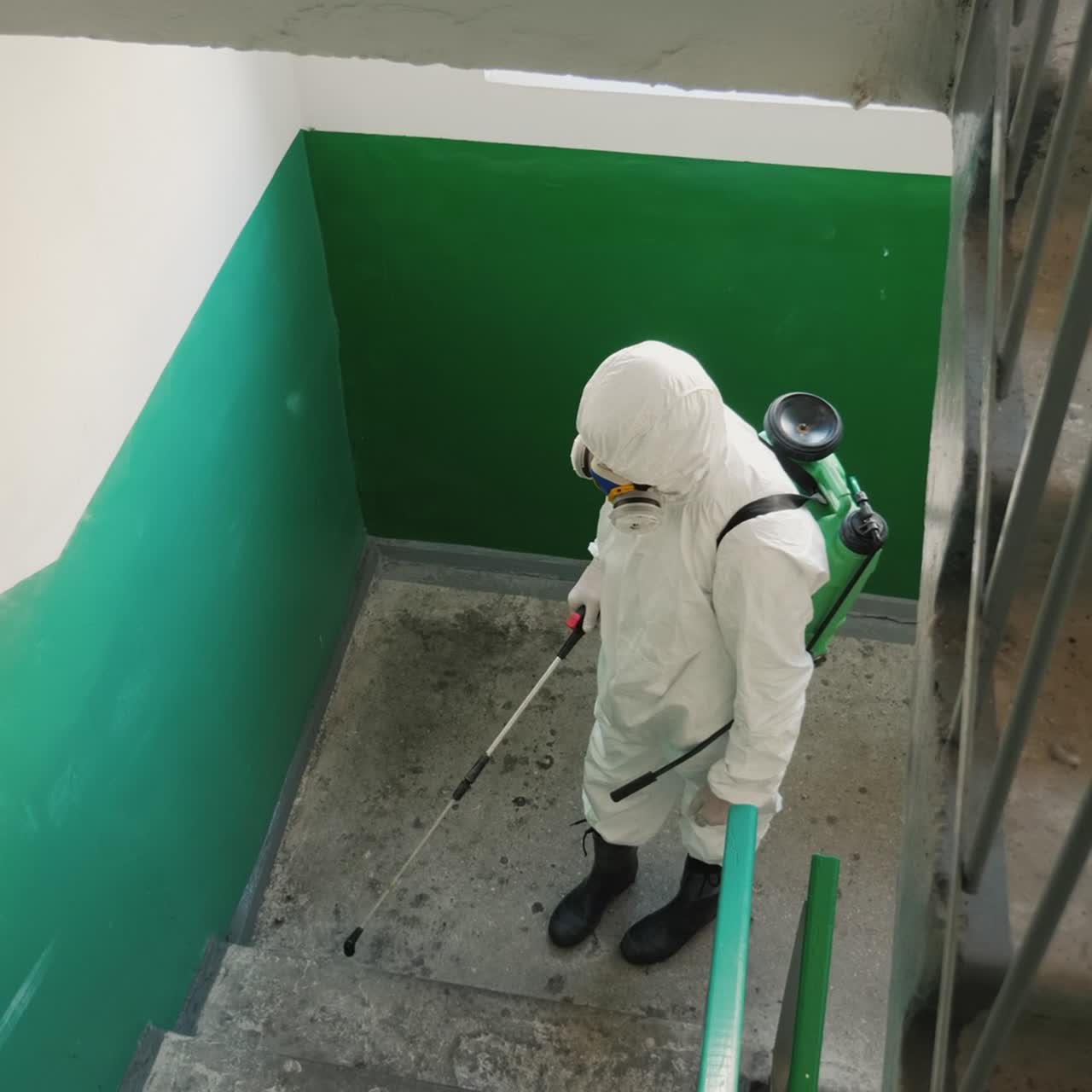 보호복을 입은 노동자는 집 현관에서 방부제를 다룬다