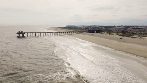 drone of an empty beach in tybee island retreating from pier