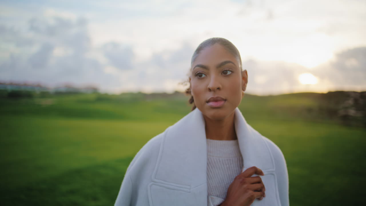 Relaxed woman going field on sunset closeup. Confident african american admiring