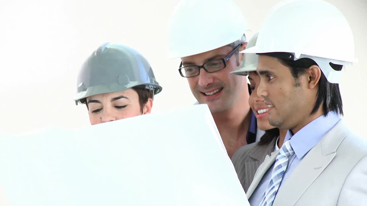 arquitectos multiétnicos estudiando planos