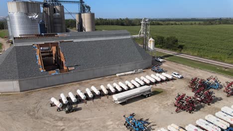 aerial drone footage storm damaged grain elevators destroyed by high winds and bad weather, midwest farm country, iowa