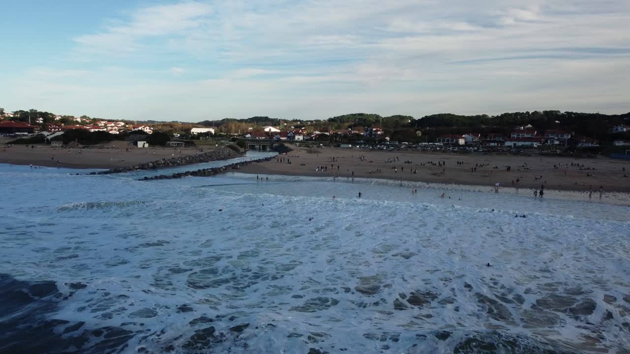 Luftfoto av en strand med bølger og folk