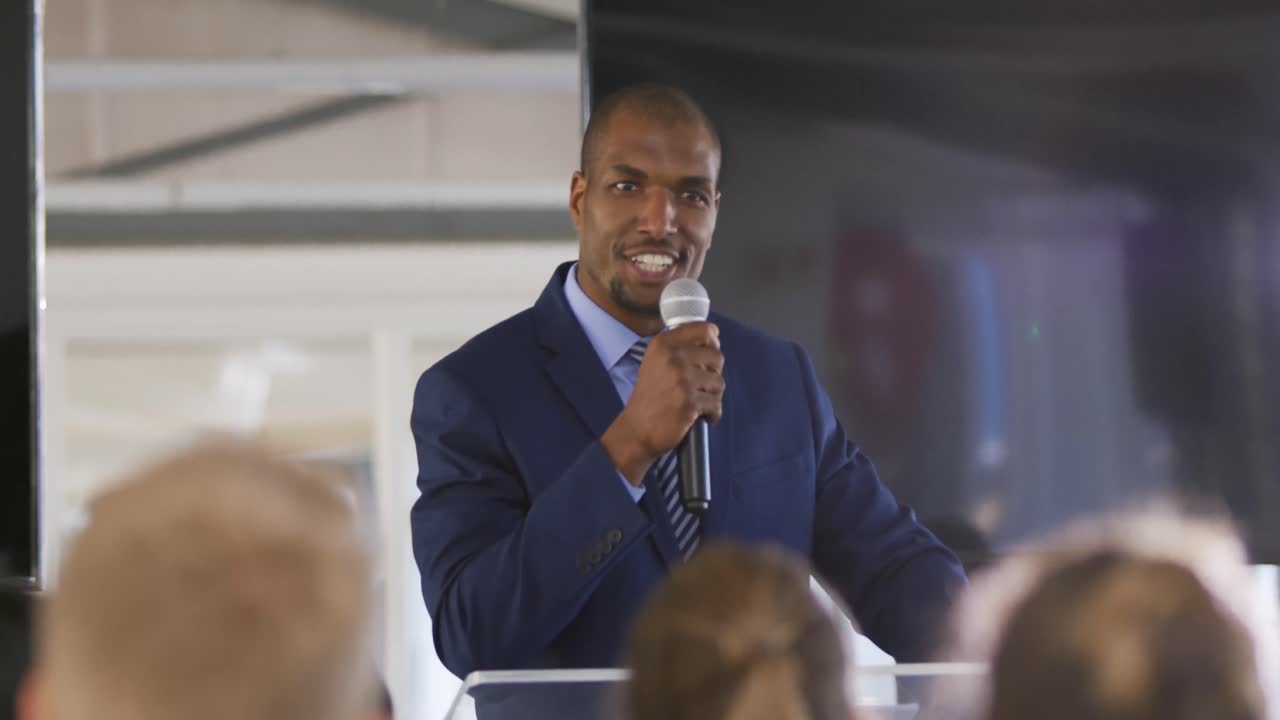 Male speaker addressing the audience at a business conference