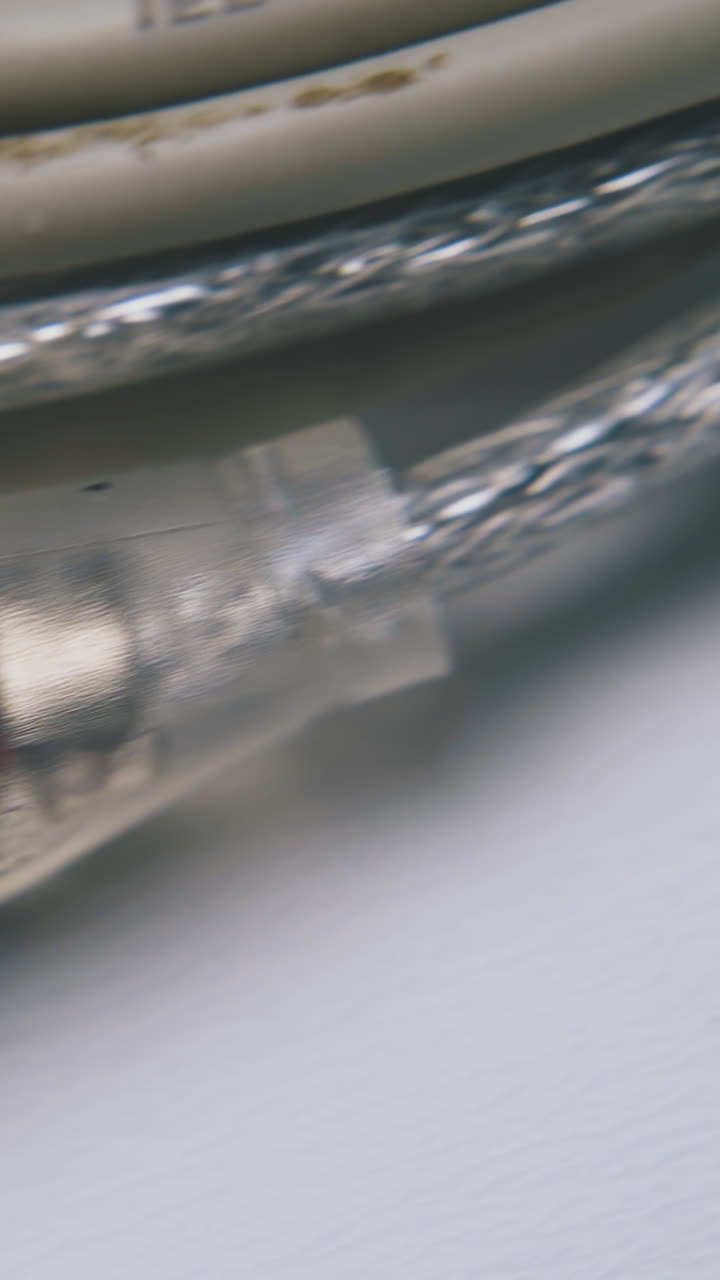 old grey usb cable with plugs for devices connection to computer on empty white surface extreme close view