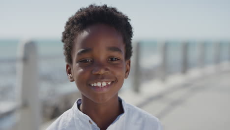 portrait little african american boy smiling cheerful enjoying warm summer vacation on seaside beach real people series
