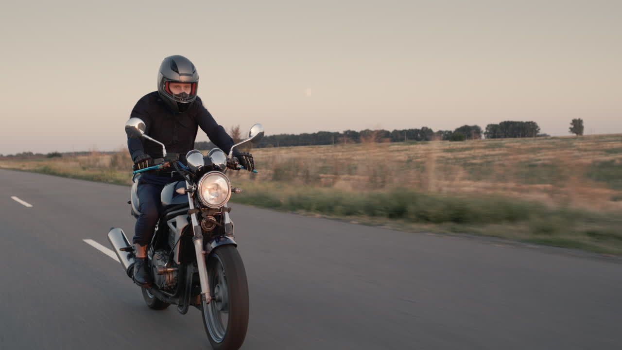 un motociclista monta una motocicleta antes del atardecer
