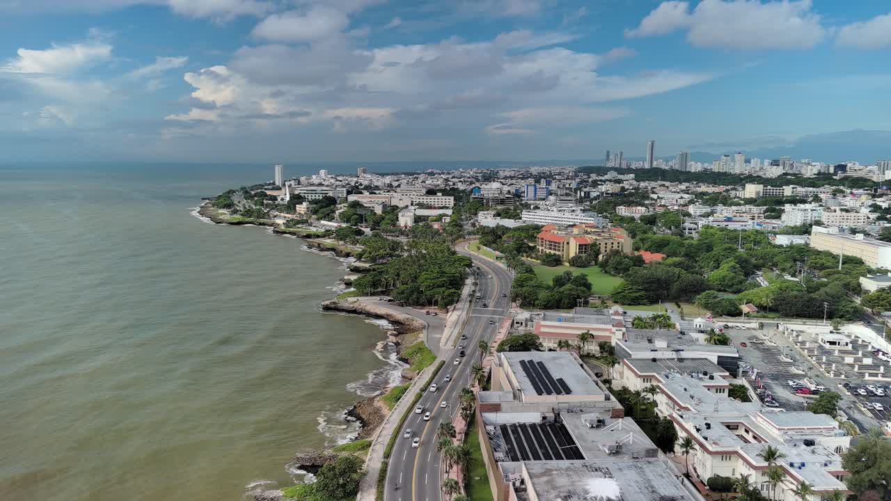 Aerial drone view of Malecón coastline in Santo Domingo. Features George Washington Avenue traffic, the Caribbean Sea, and the city infrastructure of the Dominican Republic capital
