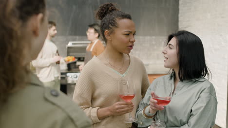 Un-Agradable-Grupo-Multicultural-De-Tres-Chicas-Charlando-Alegremente-Y-Bebiendo-Vino-En-Una-Barbacoa-En-La-Terraza-De-Una-Casa-1