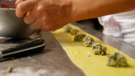panadero masculino poniendo ingredientes en la masa de pasta 4k