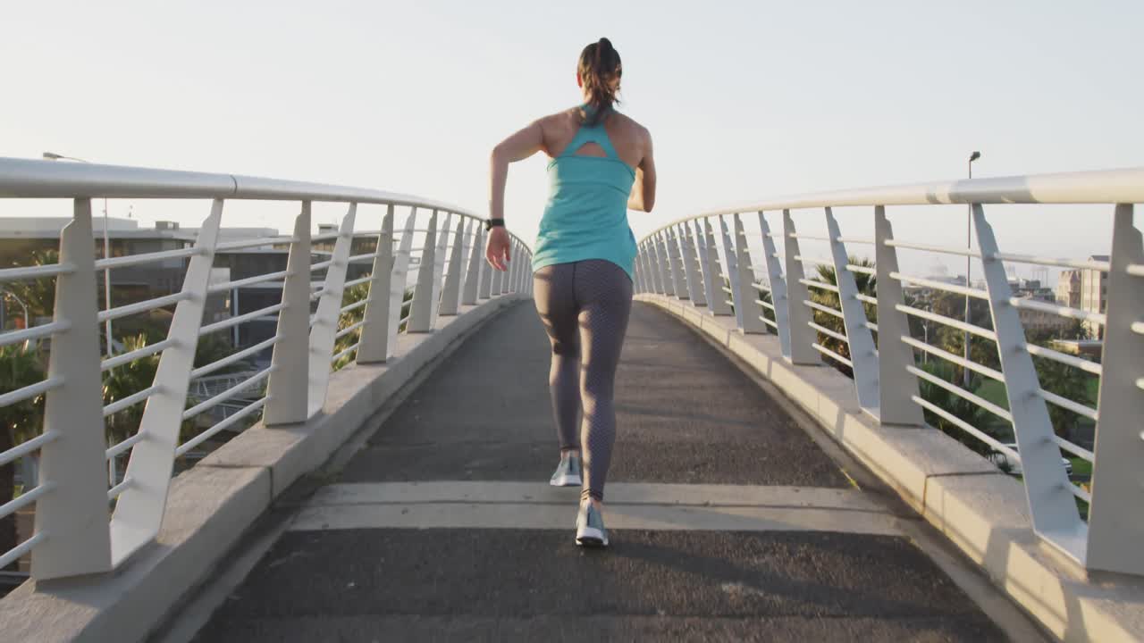 Young woman running on a bridge