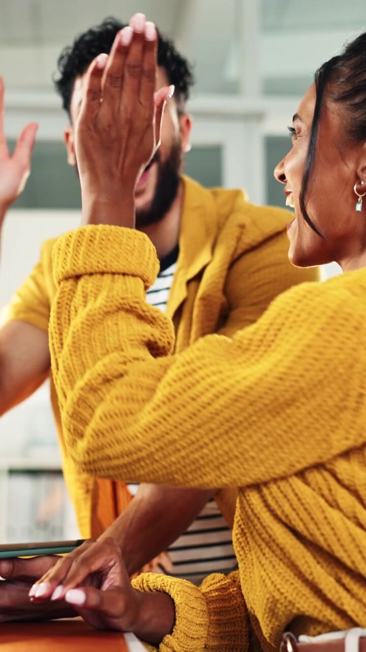 Diverse Colleagues Celebrating Success with a High Five in Modern Office