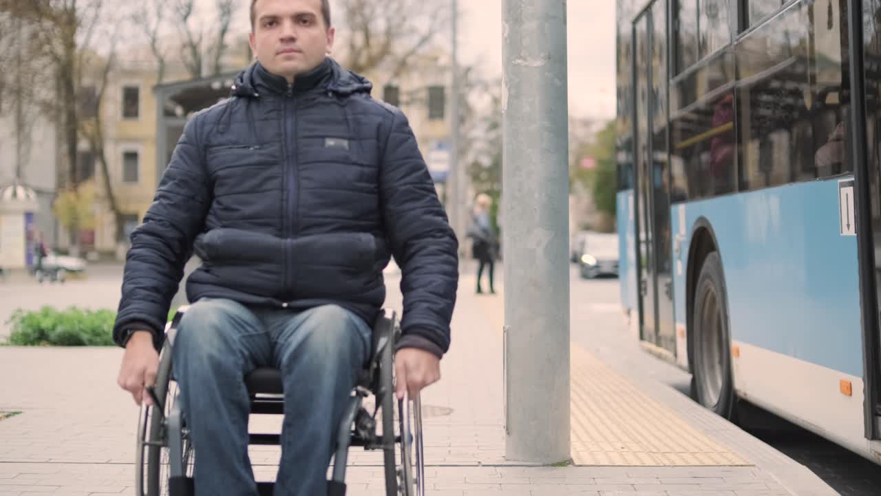 persona con discapacidad física que espera un transporte urbano con una rampa accesible